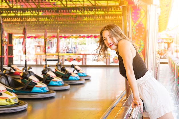 Smiling young woman enjoying near the bumper car ride