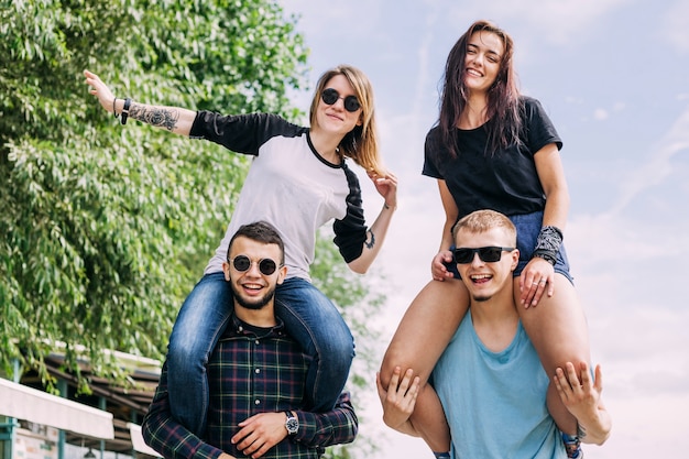 Smiling young woman enjoying the ride on boyfriend's shoulder