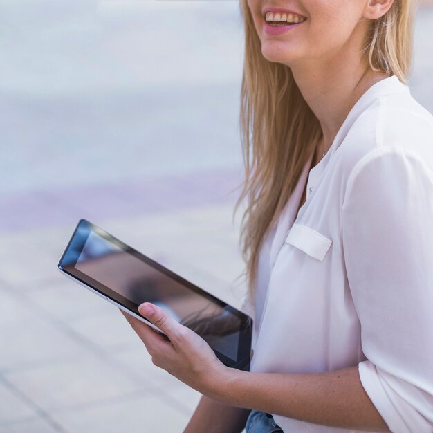 Smiling young woman holding digital tablet