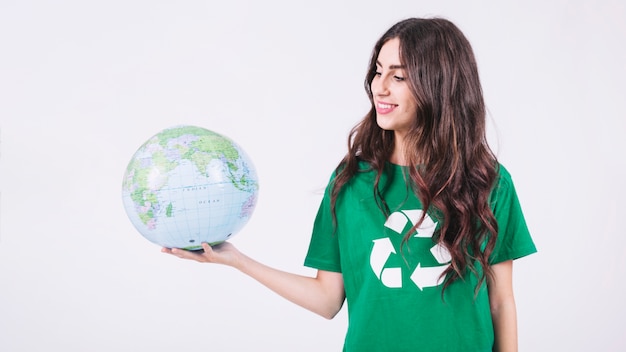 Free Photo smiling young woman looking at globe