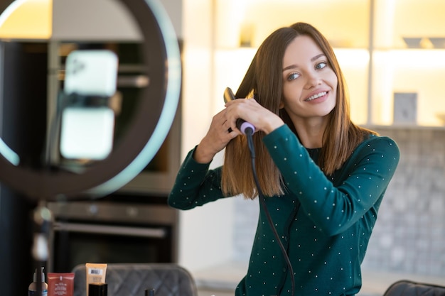 Smiling young woman showing tips on haircare