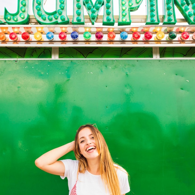 Smiling young woman standing under the light bulb word