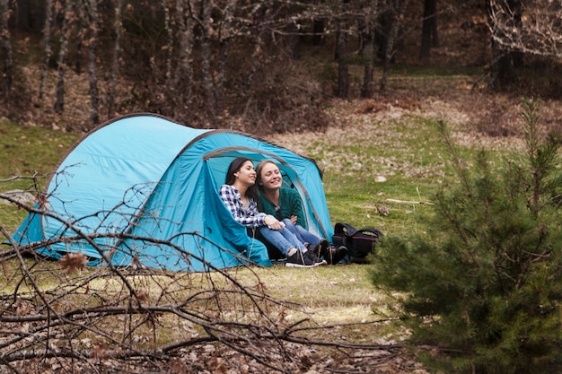 Smiling young women in a blue tent