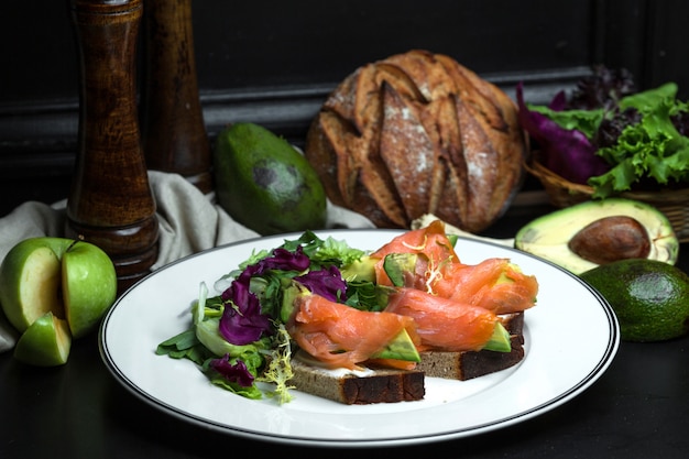 Free Photo smoked salmon bruschetta with avocado and cream cheese served with salad