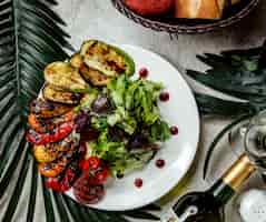 Free photo smoked vegetables aubergine tomato bell peppers served with lettuce salad