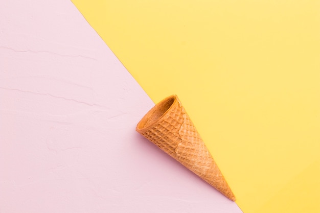 Free photo smooth empty ice cream cone on multicolored surface