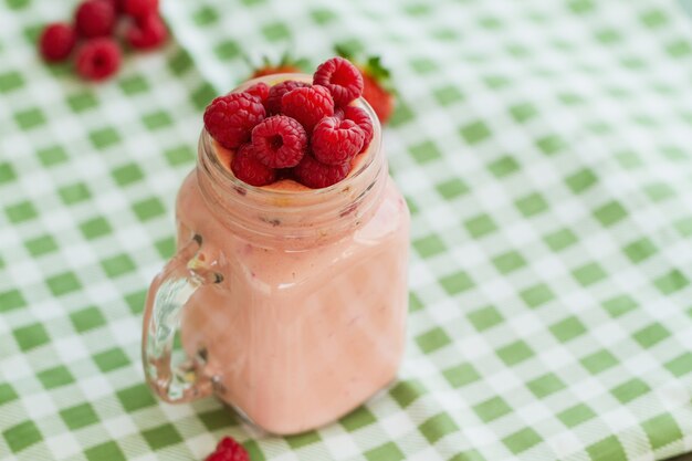 Smoothie with raspberries on table