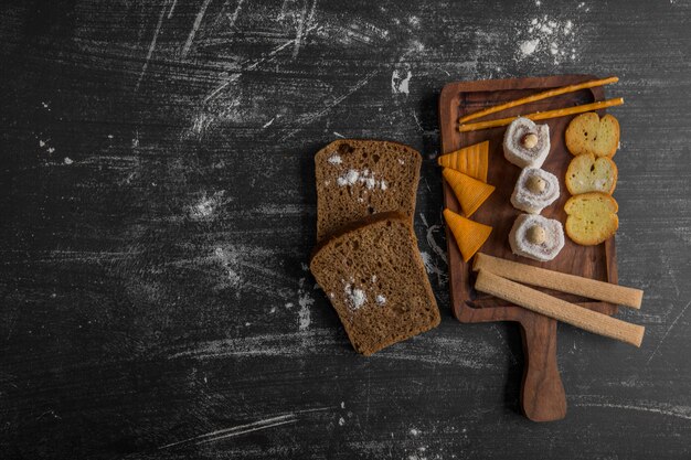 Snack board with chips and pastries, top view