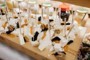 Free photo snacks like cheese and dried fruits are on wooden desk