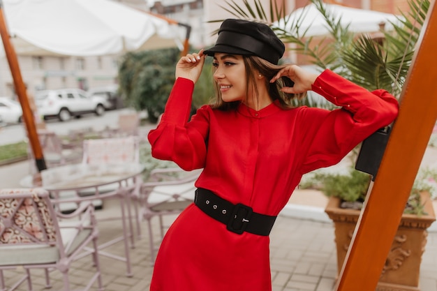 Free photo snapshot in parisian style of young fashionista. girl with comfortable short haircut poses boldly for street photo