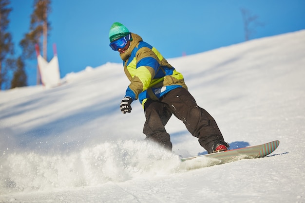 Free Photo snowboarder sliding from the mountain in winter day