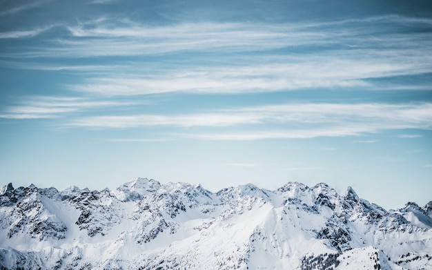 Free photo snowy mountains under a blue cloudy sky at daytime