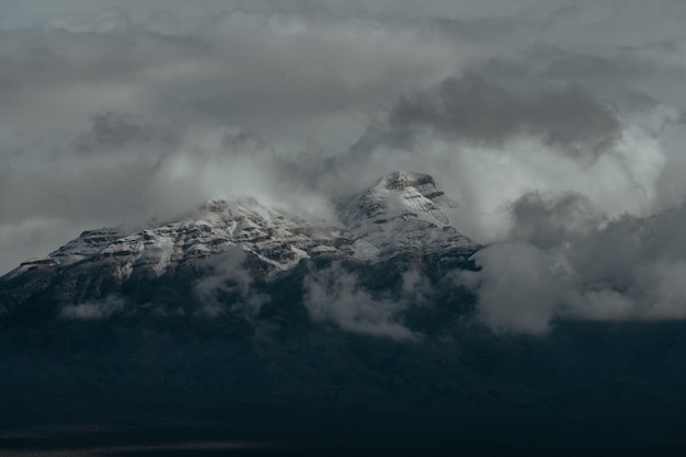 Free Photo snowy peaks of the mountains covered by the dark cloudy sky