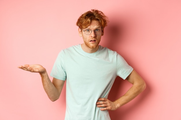 Free photo so what confused redhead man raising hand and shrugging looking puzzled dont understand something st...