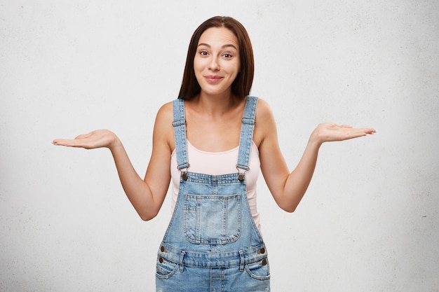 So what? Who cares? positive Caucasian brunette woman shrugging her shoulders, looking careless about problems, having calm and carefree expression on her pretty face