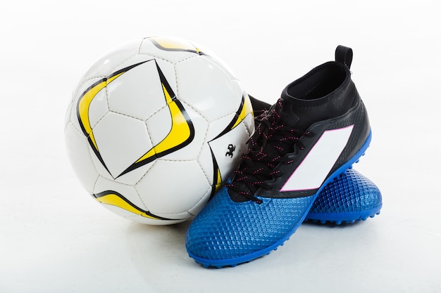 Free photo soccer ball next to cleats