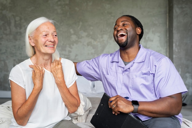 Social worker taking care of an old woman