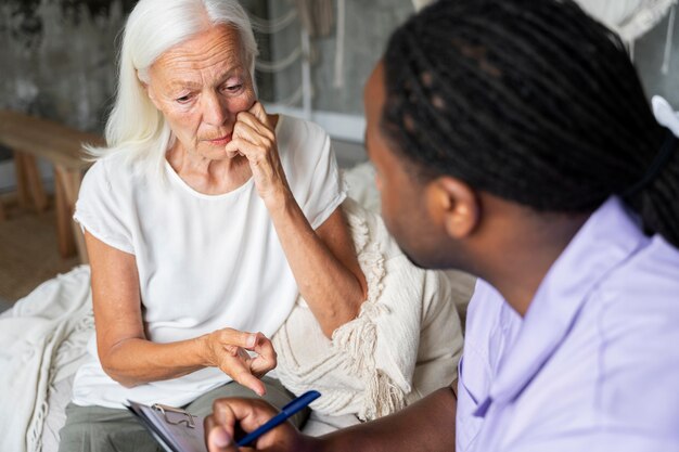 Social worker taking care of an old woman