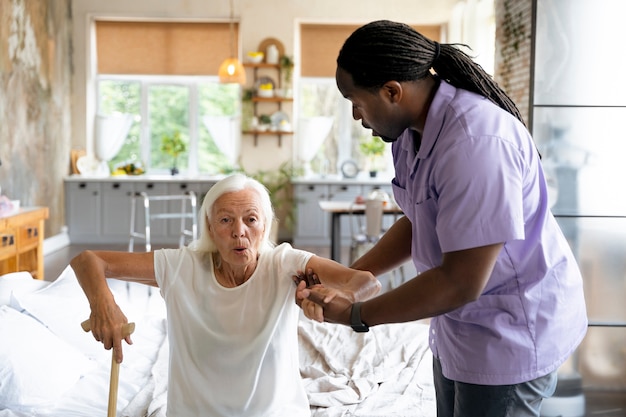 Social worker taking care of an old woman