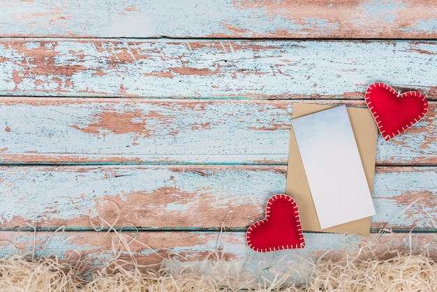 Free photo soft toy hearts with paper on table