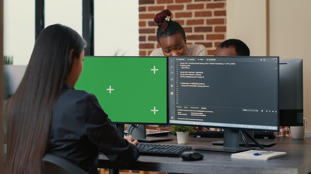 Software developer writing algorithm in front of computer with green screen chroma key mockup in ai development agency. Cyber security app developer programming machine learning software.