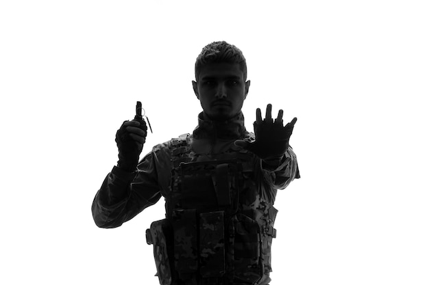 Free photo soldier silhouette army tough handsome serious strong soldier in uniform stopping with grenade