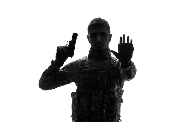 Free photo soldier silhouette tough handsome serious strong army soldier in uniform raising hand