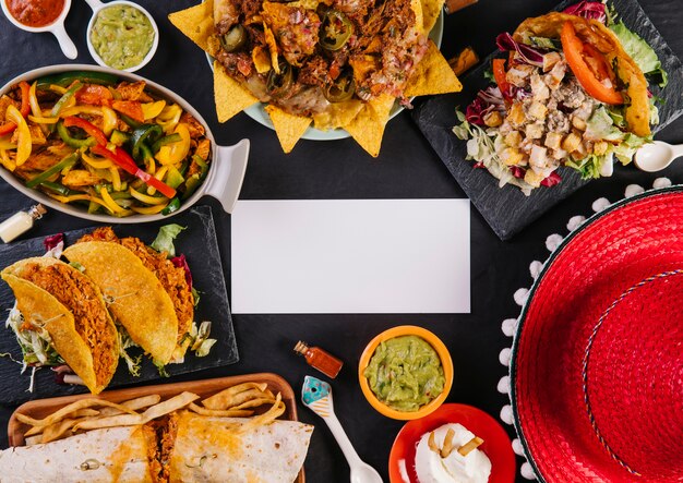 Sombrero and Mexican dishes near paper card