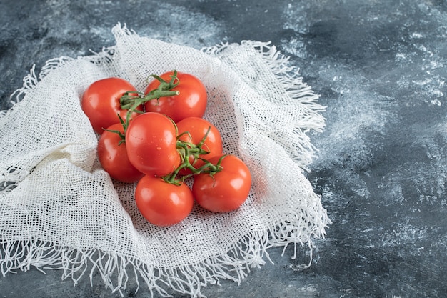 Free photo some of juicy tomatoes on white sackcloth .