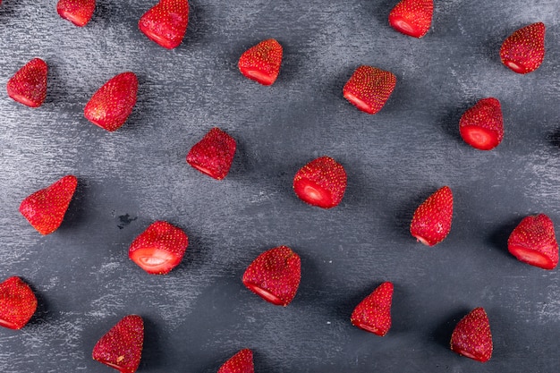 Free photo some strawberries on dark table, pattern composition