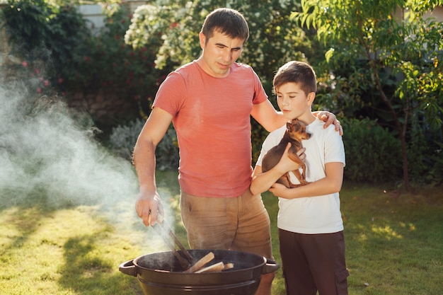 Son and father preparing food together at picnic