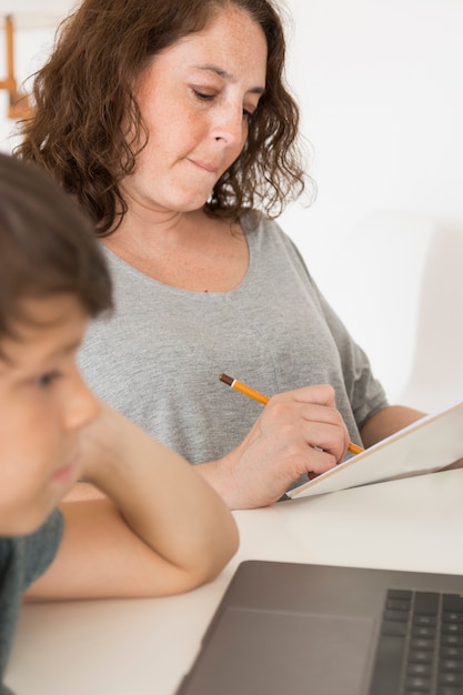 Son looking on laptop next to mom