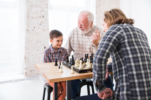 Free Photo son playing chess with dad