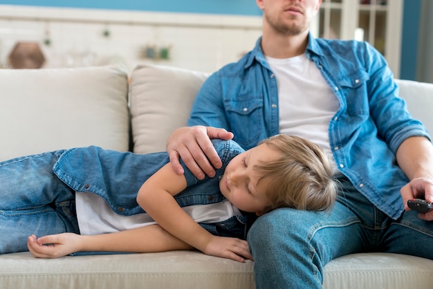 Son sleeping on father's legs