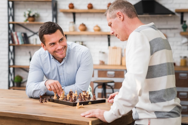 Son winning a chess game in front of his father