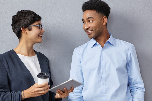 Sophisticated mixed race female and male colleagues have conversation together