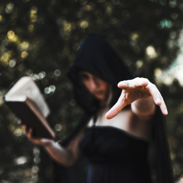 Free photo sorceress casting spell in woods daytime