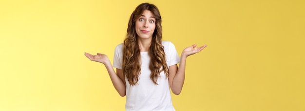 Free Photo sorry unable help clueless apathetic attractive female friend shrugging hands spread sideways full dibelief uncertain smirking unaware have no idea perplexed answer question yellow background