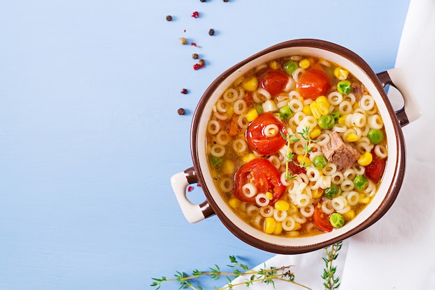 Free Photo soup with small pasta, vegetables and pieces of meat in  bowl on  blue table. italian food.