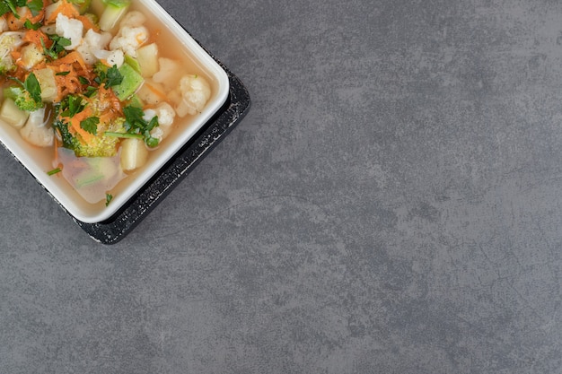 Soup with various vegetable slices on white plate. High quality photo