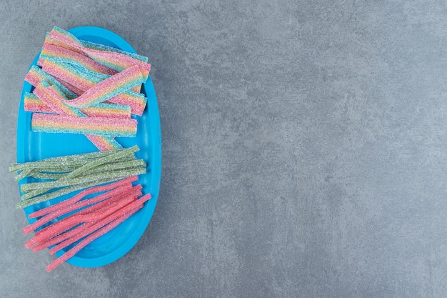 Free photo sour chewy candies on blue plate.