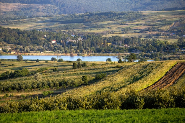 Sown fields, lush greenery, flowing river in the distance and a village near the shore in Moldova