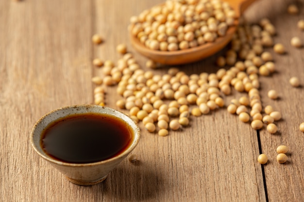 Free photo soybean sauce and soybean on wooden floor soy sauce food nutrition concept.