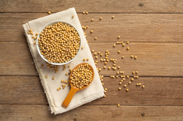 Soybean seeds on wooden floor and hemp sacks Food nutrition concept.