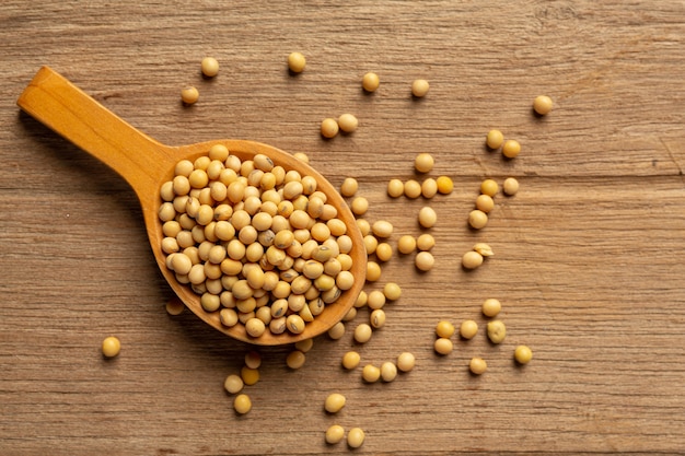 Soybean seeds on wooden floor and hemp sacks Food nutrition concept.