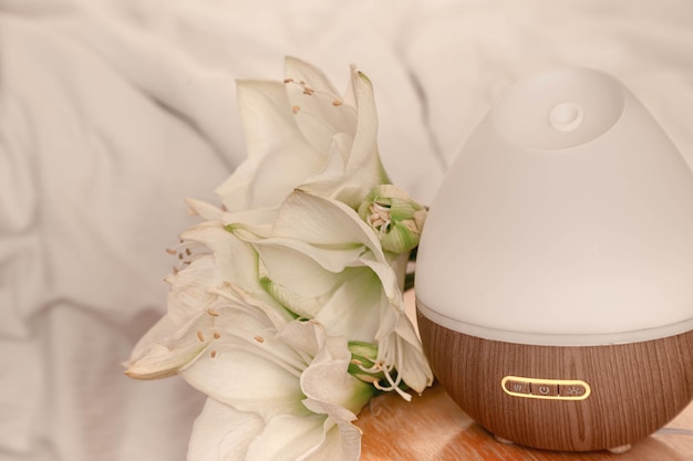 Free photo spa composition with aroma diffuser and lily flowers closeup