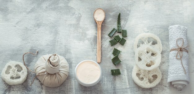 Spa composition with body care items on a light wall.