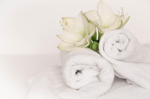 Spa composition with lily flowers and towels on a white background