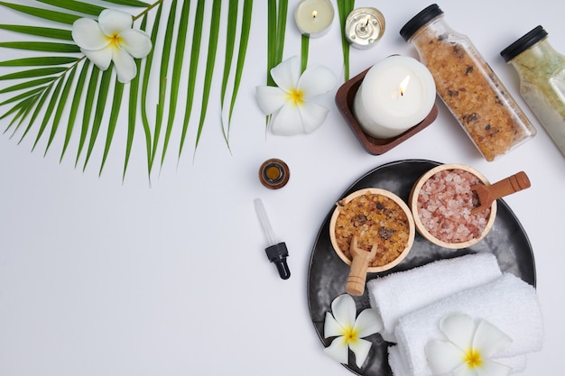 Spa concept. Beauty and fashion concept with spa set. perfumed flowers water. Relaxation and zen, Spa setting flat lay with bowl, bath salt and flowers, towel and natural soap. top view.