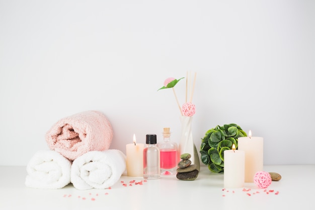 Free Photo spa products and illuminated candles on white tabletop